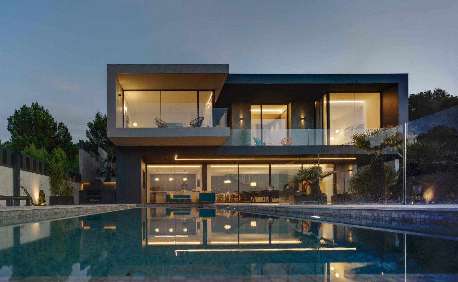 Vivienda contemporánea con piscina y fachada con vidrio.