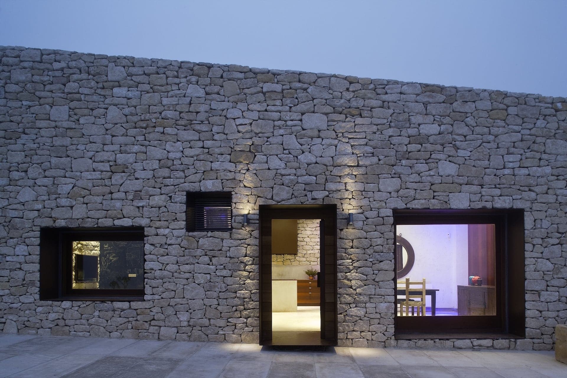 Fachada de piedra en seco casa en la montaña al atardecer — estudio de arquitectura Alicante tamatestudio